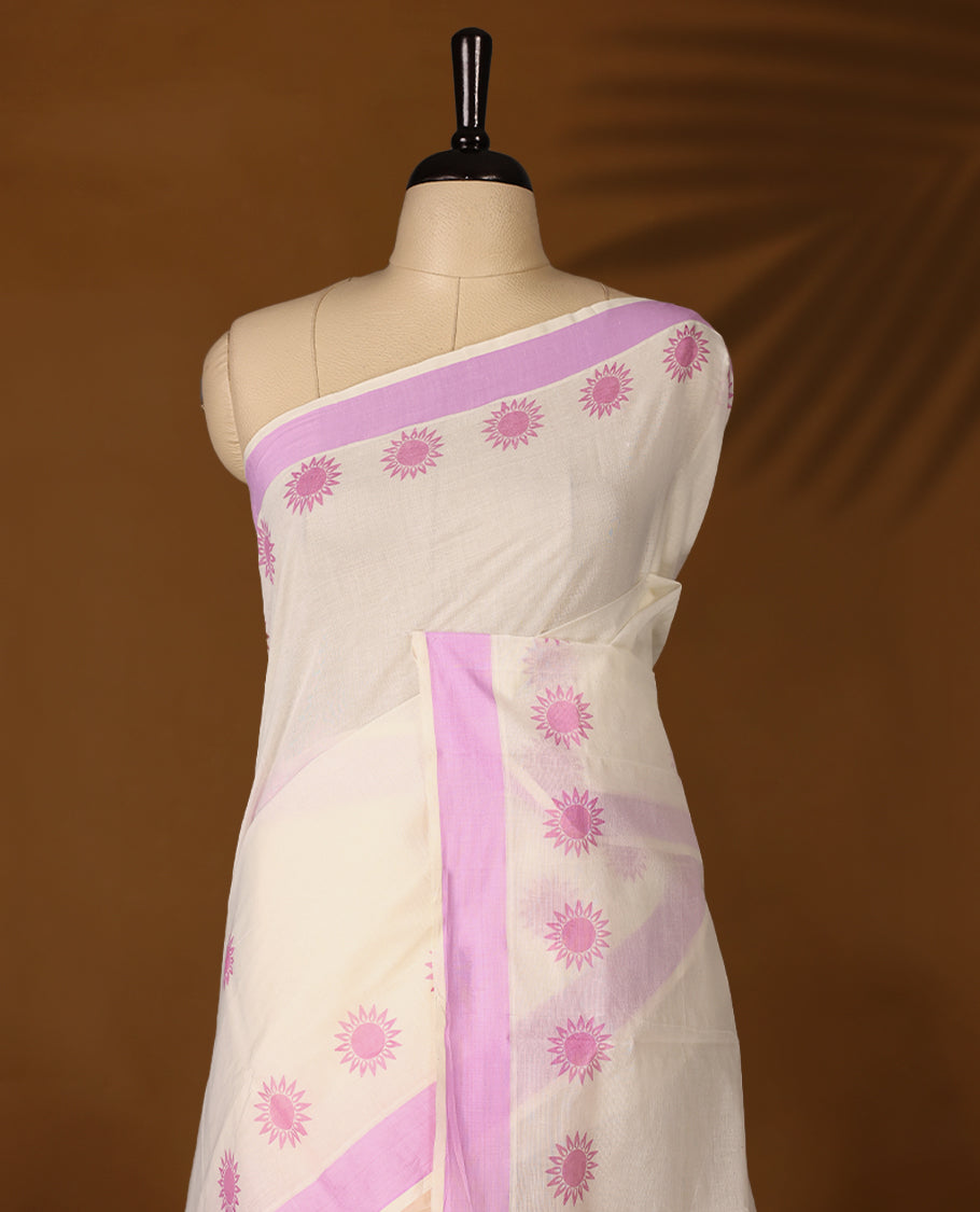 Elegant off white colour cotton Kerala saree featuring Plain body, Lavender colour border with  Flower Block prints, Paired with matching blouse offering a classic and graceful look