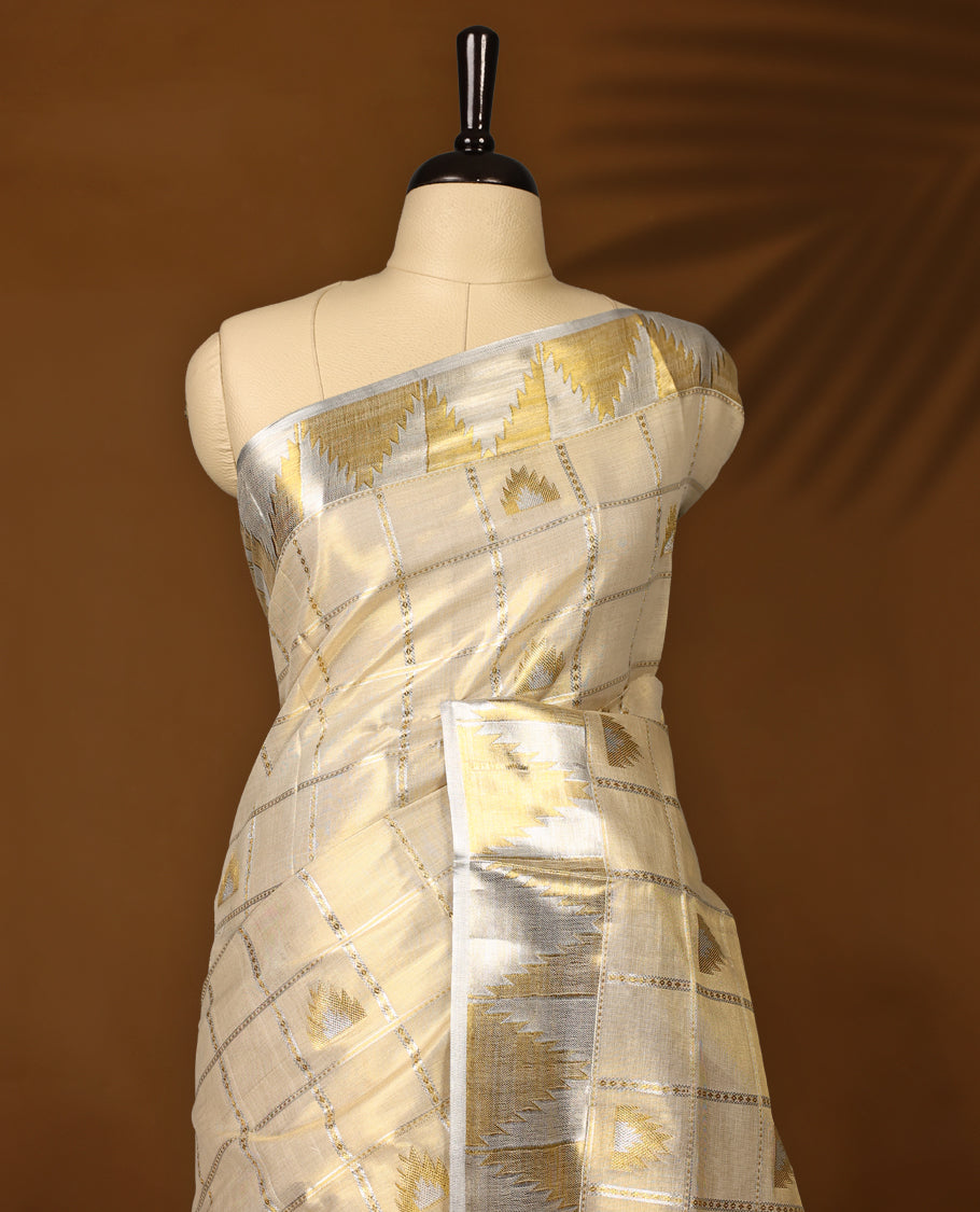 Elegant off white colour Tissue Kerala saree adorned with silver and gold geometric motifs on a checked body, enhanced by a shimmering silver kasavu border and rich golden pallu, paired with matching blouse for festive elegance.