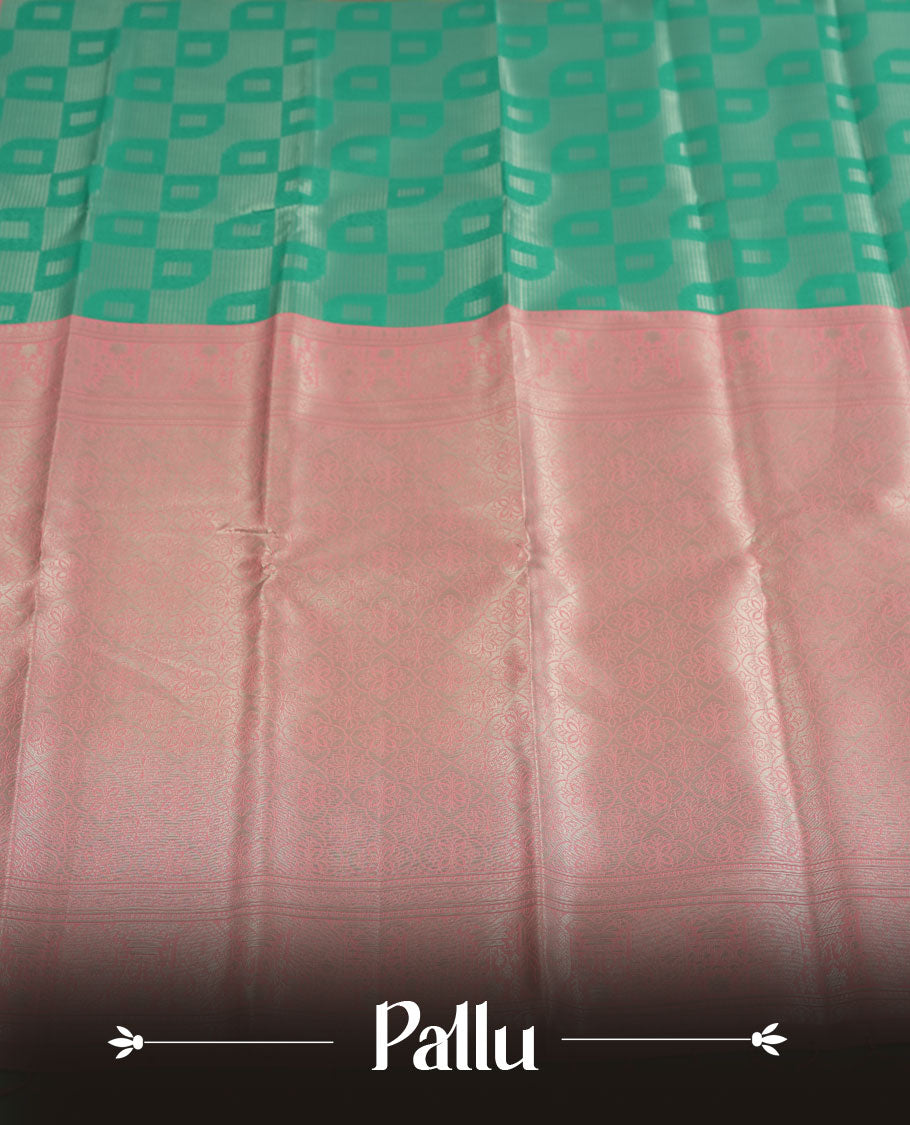 aqua green colour semi silk saree adorned with silver zari designs on the body, complemented by a contrasting pastel pink border and pallu, and paired with a matching blouse piece.