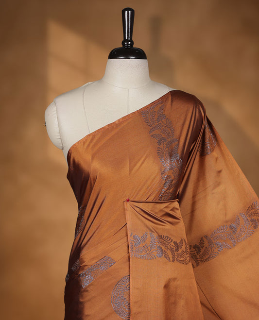 Mustard colour semi soft silk saree adorned with delicate woven floral kodi motifs on the body, complemented by a contrast navy blue colour woven pallu with intricate detailing and tassel accents without border & Comes with a matching blouse piece.