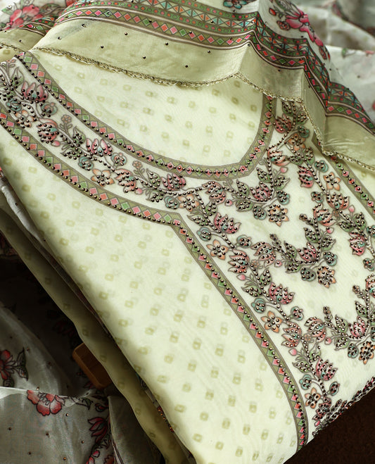 Elegant pista green churidhar material highlighted with subtle floral,stone and vine motifs, complemented by a printed dupatta and plain matching bottom, creating a graceful look perfect for festive and casual wear.