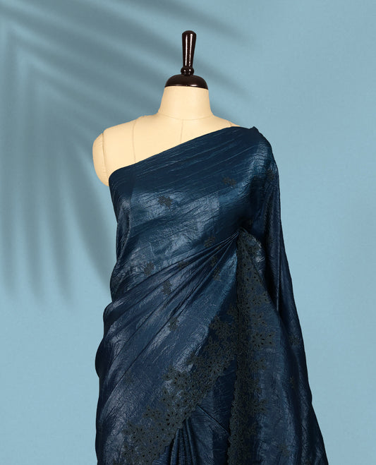 Midnight Blue Colour crush soft silk saree boasts a lustrous crinkled texture with subtle self colored floral Motifs on the body and an elegant Floral thread cutwork border, paired with a matching blouse.