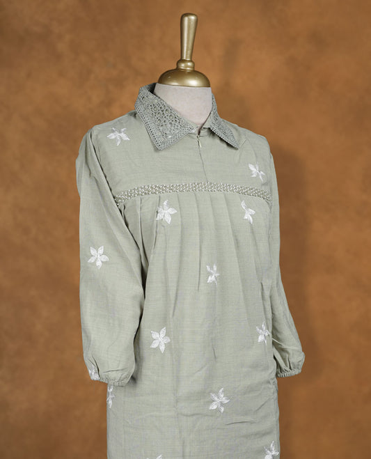 Sage green embroidered nightwear kurti with crochet-detailed shirt collar, scattered white floral motifs, heavy floral hem embroidery, and three-quarter sleeves with elasticated cuffs