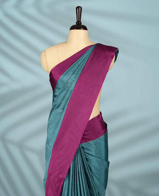 Teal green colour body with subtle zari motifs, complemented by a rich magenta border, comes with a matching blouse.