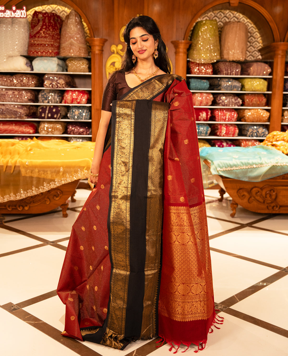 Maroon with Black colour Chettinad cotton saree featuring Gold zari strips with peacock motifs on body, complemented by contrast colour border with zari design & grand pallu, comes with matching blouse piece.