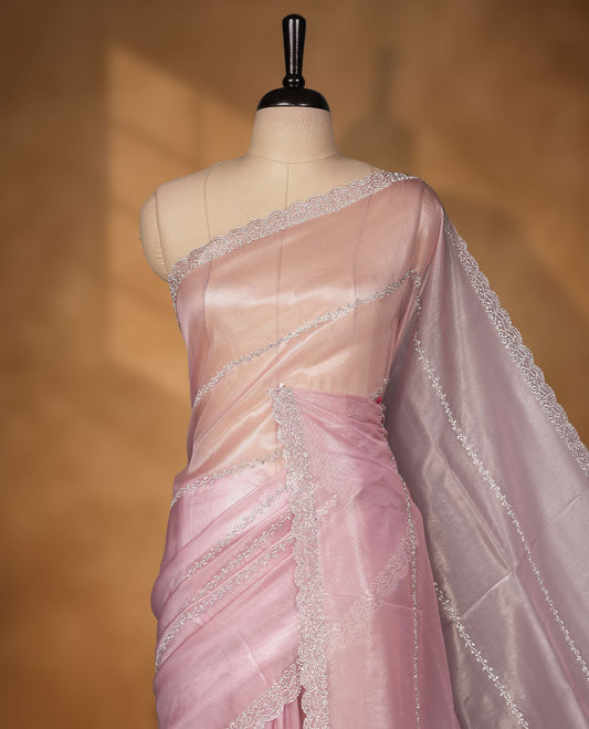 Pastel pink Colour net shimmer fancy saree adorned with white stone buttas with design over the body, paired with a delicate stone worked border and matching blouse