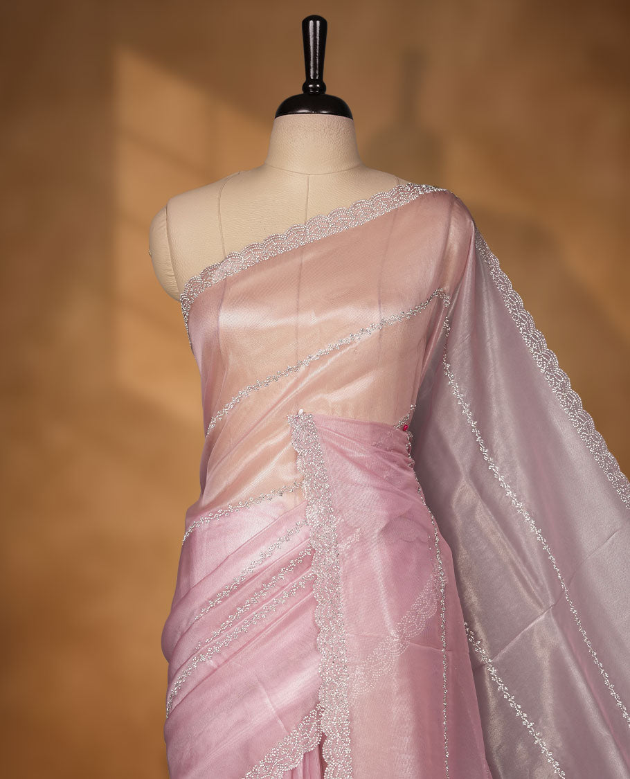 Pastel pink Colour net shimmer fancy saree adorned with white stone buttas with design over the body, paired with a delicate stone worked border and matching blouse