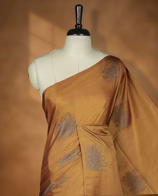 Dark Mustard colour semi soft silk saree adorned with delicate woven floral motifs on the body, complemented by a Self colour woven pallu with intricate detailing and tassel accents without border & Comes with a matching blouse piece.