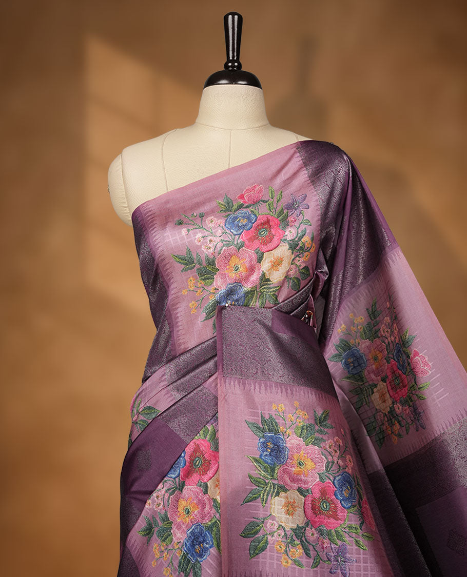 Grape color semi tussar Banarasi saree featuring vibrant multi-color floral prints across the body, with shimmering geometric zari patterns, a rich gray-red border, and a matching blouse detailed with silver woven buttas.