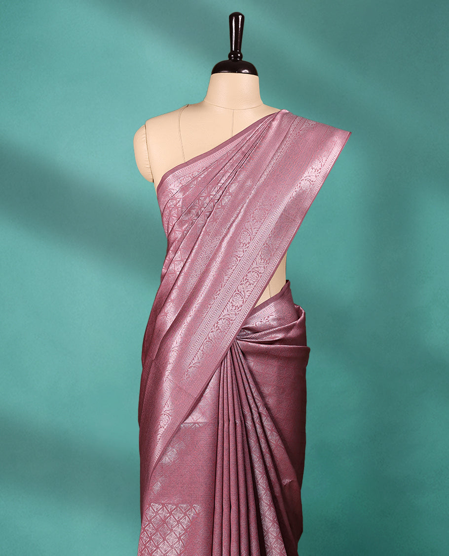 Pastel Onion coloured semi silk saree featuring a Silver coloured Zari Diamond design on the body, paired with a Self coloured border and matching blouse.