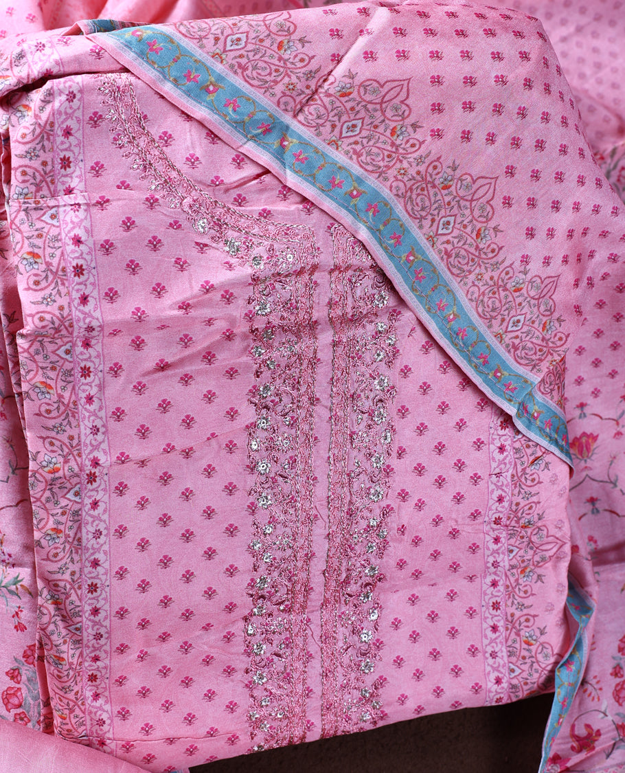 Pink colour churidhar material with intricate embroidery on the neckline and delicate floral prints, paired with a matching printed dupatta and plain bottom.