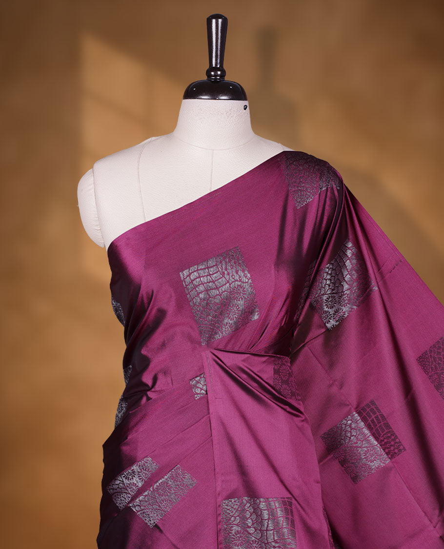 Deep purple colour semi soft silk saree adorned with delicate woven Square motifs on the body, complemented by a Self colour woven pallu with intricate detailing and tassel accents without border & Comes with a matching blouse piece.