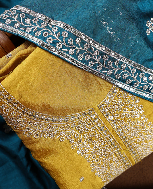 Cookie brown colour churidhar top embellished with intricate silver embroidery, paired with a plain teal bottom and a rich teal dupatta featuring delicate butti work and ornate silver embroidered borders.