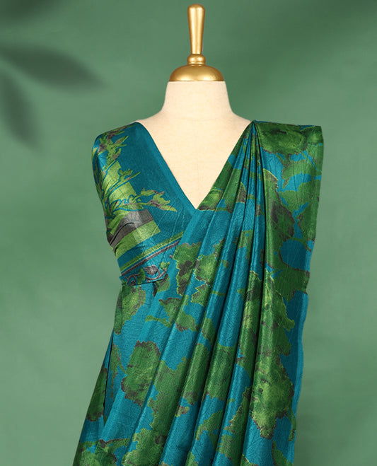 Teal blue colour Manipuri saree features a body with abstract leafy patterns in shades of green, without border, and comes with a matching blouse.