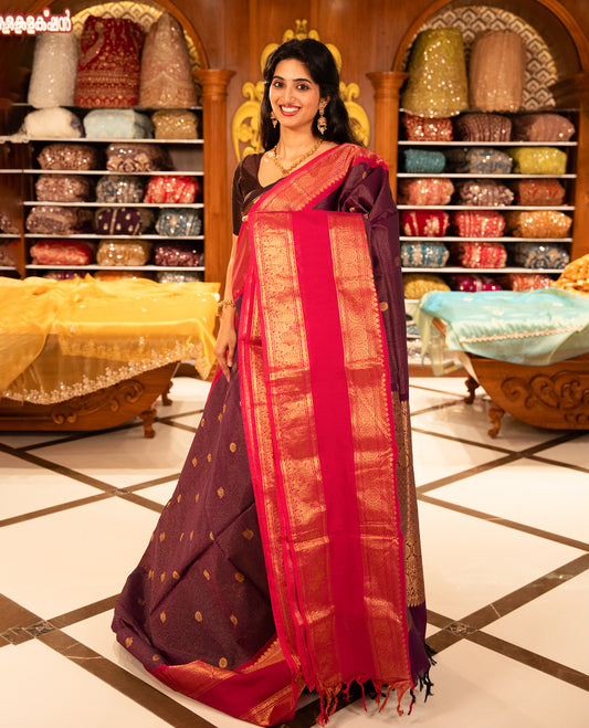 Purple with Magenta Chettinad cotton saree featuring Gold zari strips with peacock motifs on body, complemented by contrast colour border with zari design & grand pallu, comes with matching blouse piece.