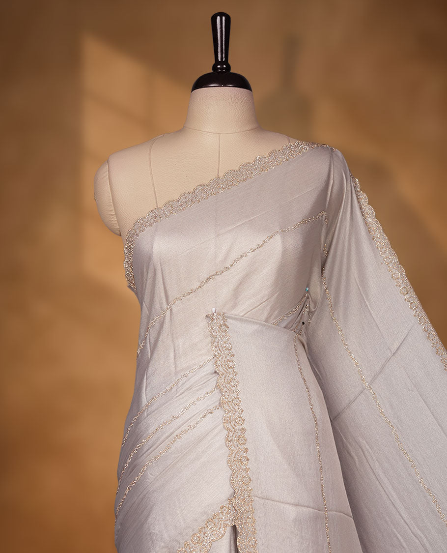 Silver Pink colour net shimmer fancy saree adorned with scattered white stone buttas, paired with a delicate stone worked border and matching blouse.