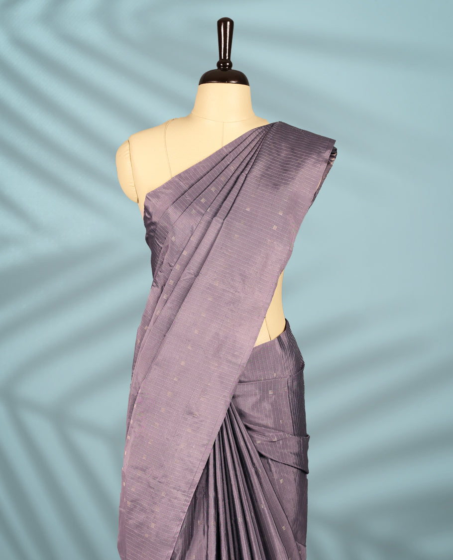Greyish Purple colour semi silk saree features a subtle checkered pattern woven with delicate threadwork across the body, crafted without a border and paired with a matching blouse