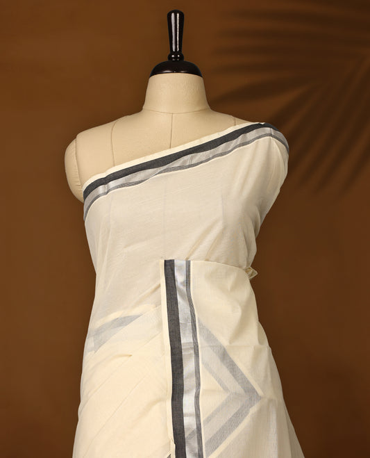 Elegant off white colour Kerala cotton saree with silver and black dual tone borders, Soft, breathable, and paired with a matching blouse, it’s perfect for festive occasions, office wear, or elegant day outings.