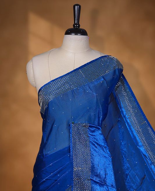 Royal Blue colour chiffon designer saree, featuring dainty scattered stones on the body, enriched with dense stone work and a heavy metallic stone border and pallu, paired with a matching blouse.