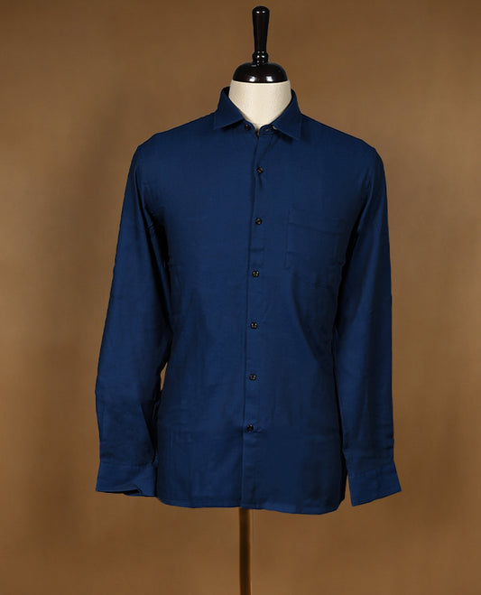 Deep blue colour Peter Eglend men’s shirt in a relaxed formal fit, featuring a smooth plain finish with full sleeves, classic collar, and chest pocket ideal for office and semi formal occasions.