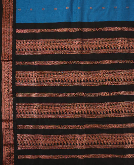 Blue colour mixed Kalyani cotton saree featuring Copper zari motifs throughout the body, paired with a Black colour traditional border and pallu, with matching blouse