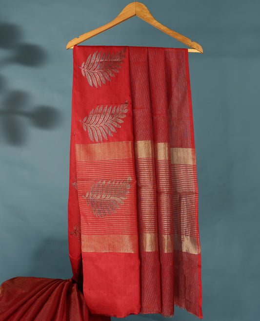 Red Colour Semi Tussar Silk saree featuring golden zari horizontal lines across the body, adorned with bold Leaf motifs on the border, paired with a matching blouse.