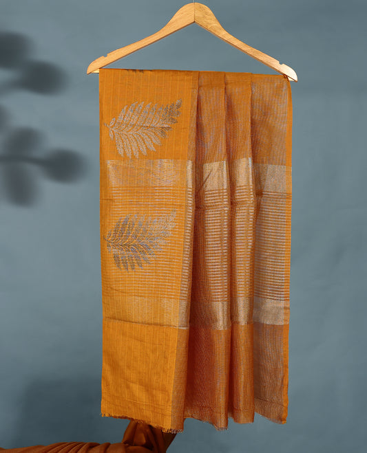Mustard Colour Semi Tussar Silk saree featuring golden zari horizontal lines across the body, adorned with bold Leaf motifs on the border, paired with a matching blouse.