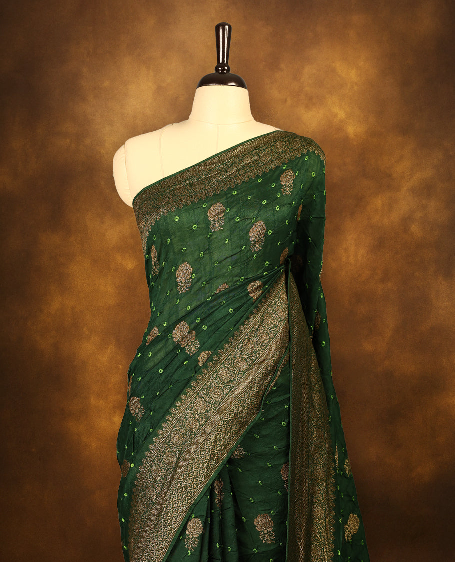 Deep green colour Banarasi Bandhani silk saree featuring light parrot green hand Bandhani patterns with intricate Banarasi motifs, complemented by antique zari woven border and grand pallu, paired with matching antique zari brocade blouse.