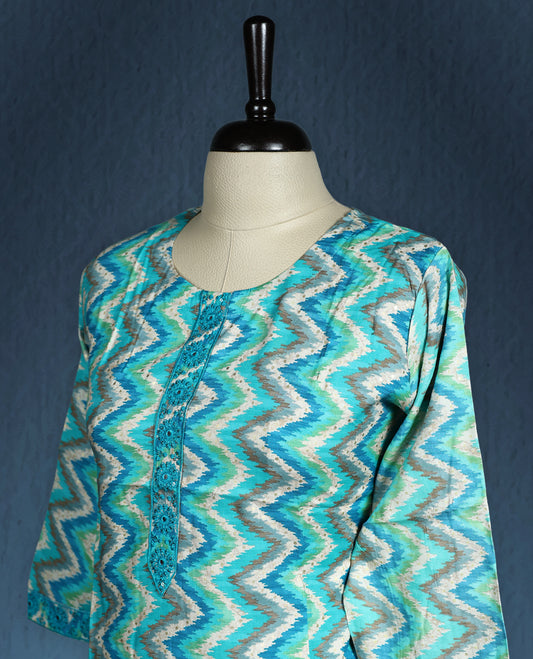 Aqua blue colour kurti with an all over zigzag pattern in shades of white and teal, styled with a round neckline featuring a short button placket, and complemented by three quarter sleeves