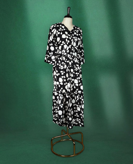 Black rayon kurti featuring bold white floral prints, designed with a V neckline, front button detailing, and a gathered waist, breezy and modern choice for casual wear.