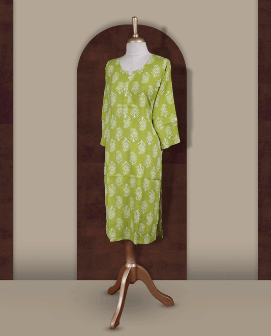 Light green colour printed kurti with round notch neck design and button detailing, straight 3/4th sleeves, and all-over white block floral prints.