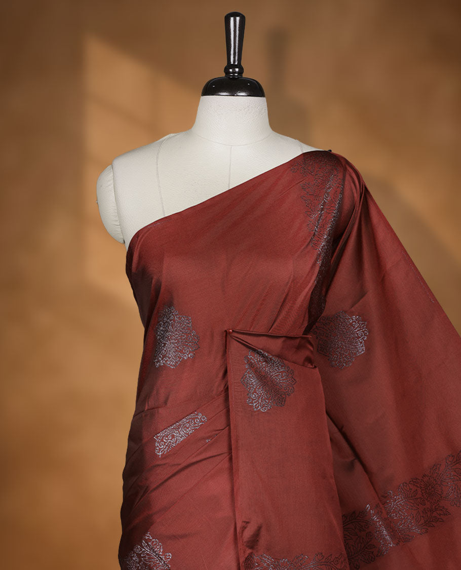 Deep red colour semi soft silk saree adorned with delicate woven floral kodi motifs on the body, complemented by a Self colour woven pallu with intricate detailing and tassel accents without border & Comes with a matching blouse piece.