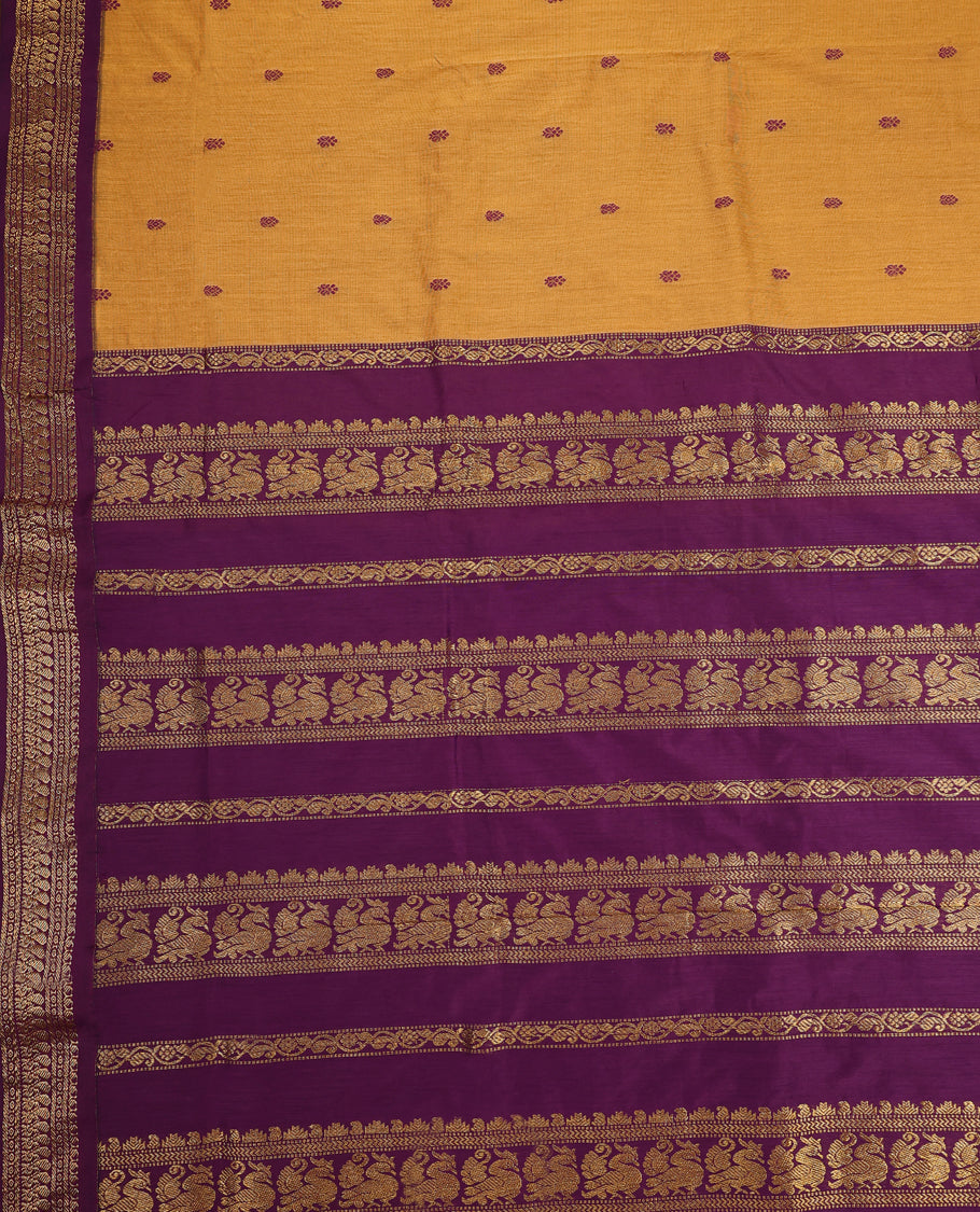 Mustard Yellow colour Kalyani cotton saree featuring woven maroon butta motifs throughout the body, paired with a rich Purple colour traditional zari woven border and pallu, with matching blouse.