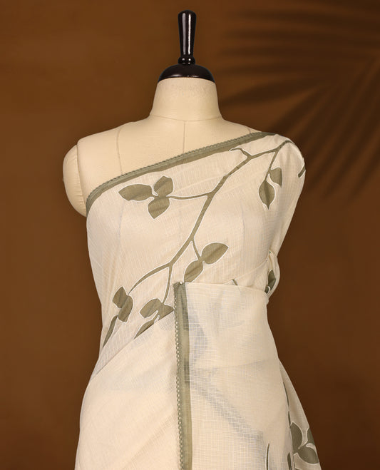 Cream colour Tussar cotton Kota saree featuring elegant Olive green leafy branch motifs across the body, accentuated with a subtle Olive green border, and paired with a matching blouse for a graceful and minimal look.