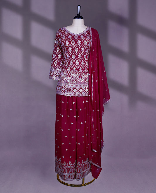 Rich maroon colour sharara set featuring a V neckline, three quarter sleeves, intricate white thread embroidery, a matching flared bottom, and a beautifully adorned dupatta