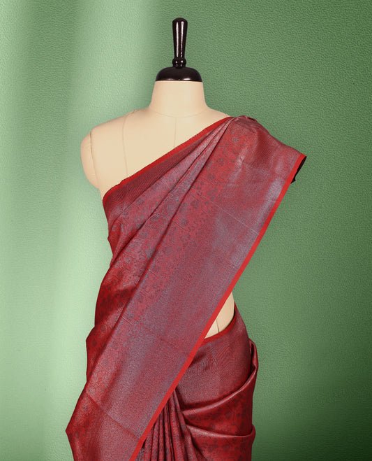 Red colour semi silk saree featuring neem zari floral kodi motifs all over the body, complemented by a rich self colour woven border, with matching blouse.