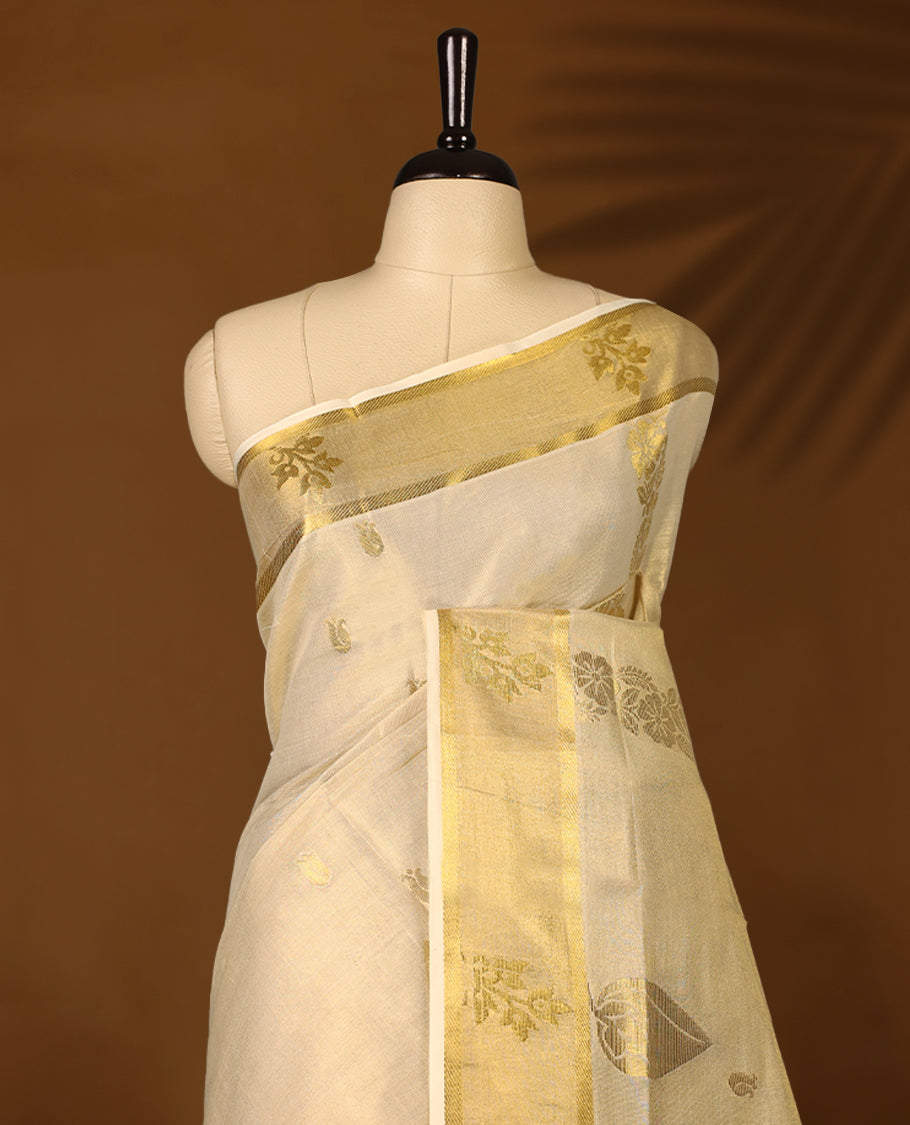Elegant Light Gold colour Tissue Kerala saree featuring Gold Zari Motifs on body, traditional golden zari kasavu border with Floral Motifs & Rich Pallu  offering a classic and graceful look, paired with a matching blouse.