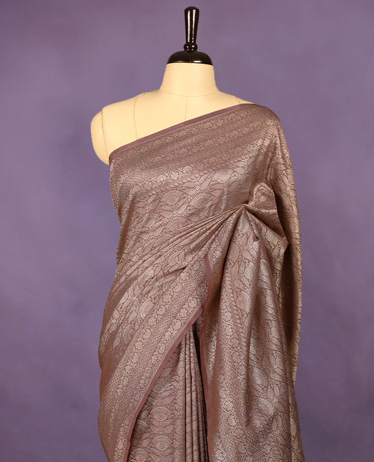 Pastel brown colour semi Banaras Katan saree featuring an antique silver zari jacquard body, complemented by a self colour traditional border with a floral kodi design, paired with a matching blouse