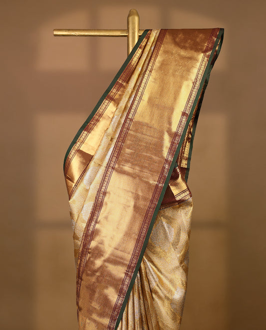 Gold colour tissue brocade saree with gold and silver zari Bold pattern on body, gold zari traditional mango and peacock work brown & green border, rich matching pallu with Antique zari motifs, paired with matching blouse.