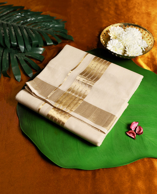 Beige pure handloom cotton double dhoti with a broad golden zari border featuring intricate woven patterns, offering breathable comfort and timeless elegance, perfect for weddings, rituals, and festive wear.