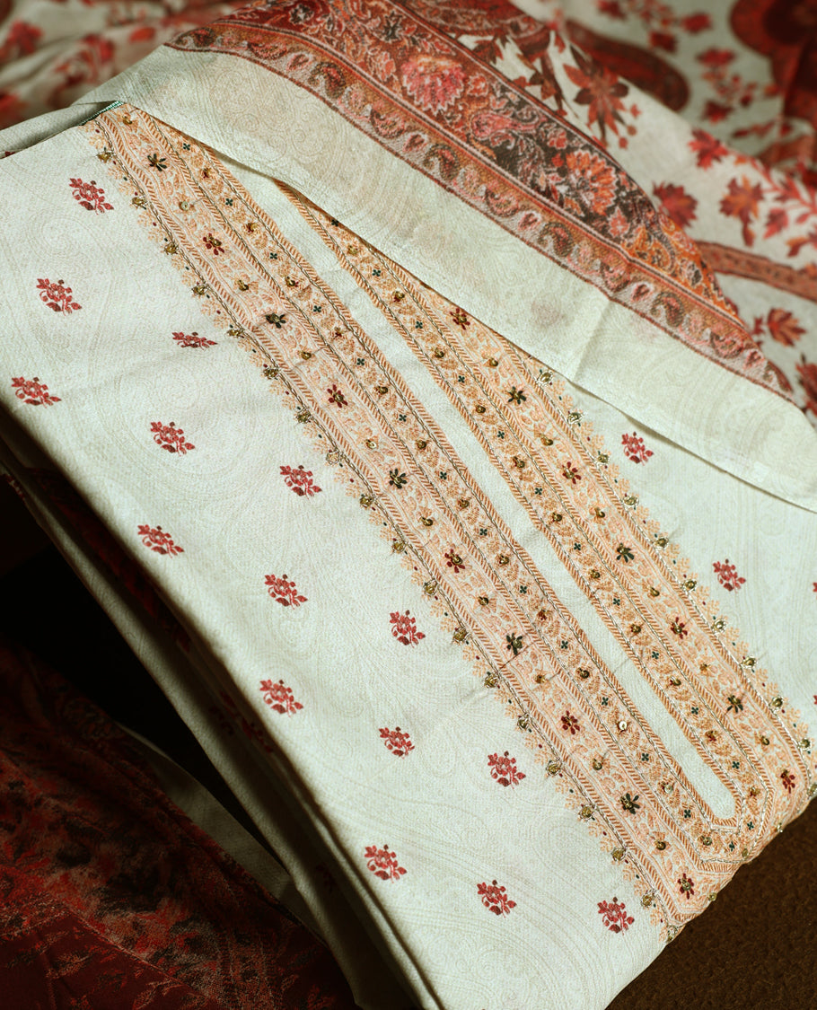 Beige colour churidhar material adorned with delicate floral embroidery and sequin accents, paired with a plain matching bottom and a richly printed dupatta in maroon and rust tones for a graceful ethnic look.