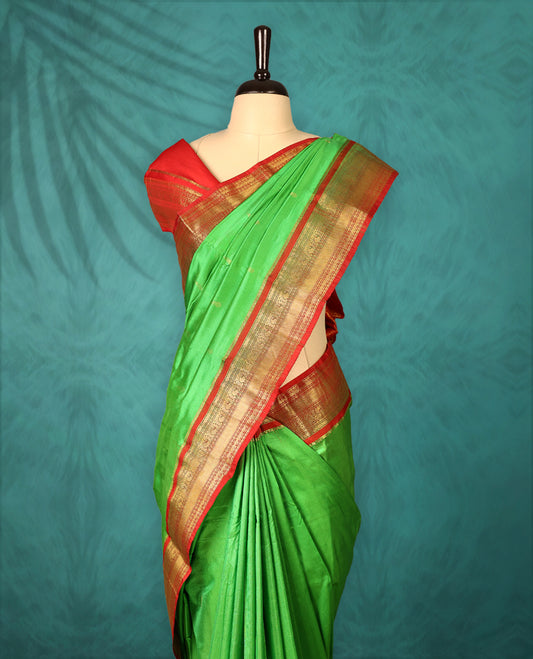 Light Green colour Traditional Kancheepuram Silk saree with small gold motifs on body, Rich Red traditional border with intricate gold zari weaving, grand zari pallu, perfect for Bharatanatyam, with matching blouse.