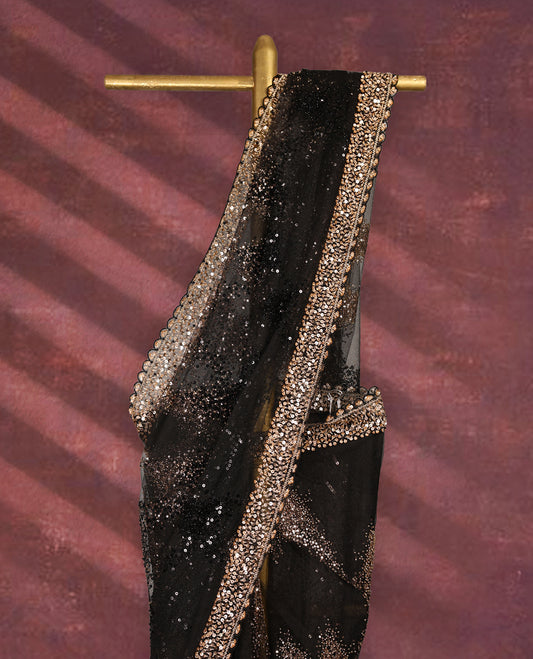 Black colour net designer saree embellished with all over shimmering sequin work in diagonal patterns and a heavily sequined border, exuding glamour and elegance, paired with a matching worked blouse for a striking look