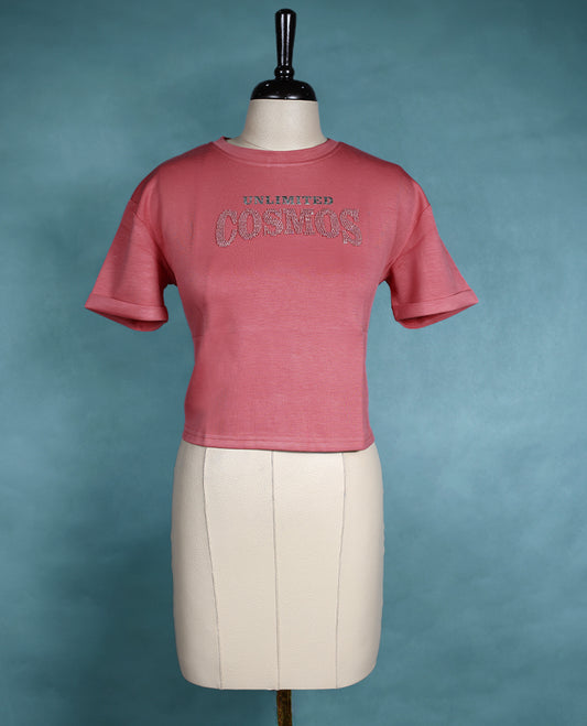 Rose pink cropped T shirt with short sleeves and rolled cuffs, featuring a subtle shimmer design on the front.