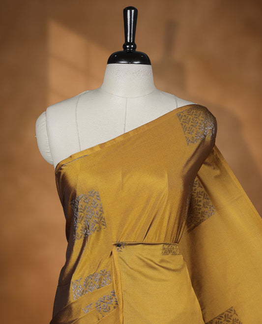Olive yellow colour semi soft silk saree adorned with delicate woven floral in square motifs on the body, complemented by a Self colour woven pallu with intricate detailing and tassel accents without border & Comes with a matching blouse piece.