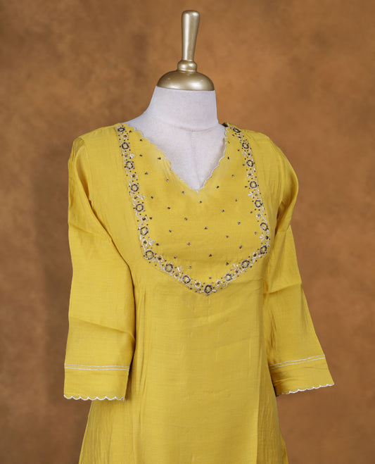 Yellow colour kurti with styled with a cut beats pattern around neckline, knee length design, and a sleeve .