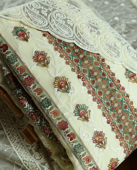 Cream churidhar material with embroidered green colour neck work, white threadwork on the body, and multicolor floral motifs in pink, green & yellow & Comes with matching plain bottom and embroidered dupatta.