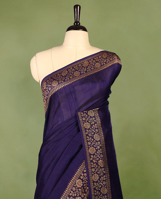 Navy Blue colour Tussar Banaras saree featuring a plain body, rich floral woven zari border and grand pallu, paired with a matching blouse for an elegant and regal traditional look.