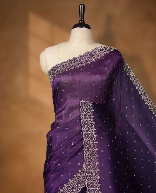 Dark Purple Colour net shimmer fancy saree adorned with scattered white stone buttas all over the body, paired with a delicate stone worked border and matching blouse featuring floral vine stone embroidery (Copy)