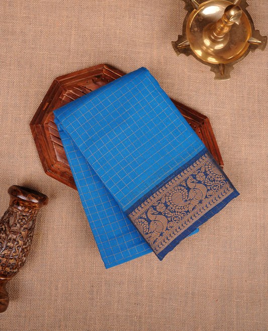 Sky blue colour sungudi cotton saree featuring gold zari check pattern across body, contrast Dark blue colour with gold zari peacock and floral pattern on border, without blouse piece.